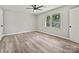 This bedroom features a ceiling fan, large windows, and vinyl wood flooring at 2544 Cedarwild Rd, Charlotte, NC 28212