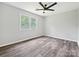 This bedroom features a ceiling fan, large windows, and vinyl wood flooring at 2544 Cedarwild Rd, Charlotte, NC 28212