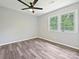 This bedroom features a ceiling fan, large windows, and vinyl wood flooring at 2544 Cedarwild Rd, Charlotte, NC 28212