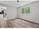 Bright bedroom with a view, featuring modern flooring, gray walls, and a stylish light fixture at 2544 Cedarwild Rd, Charlotte, NC 28212