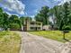Traditional two-story home with a long driveway, front lawn, and mature trees at 2544 Cedarwild Rd, Charlotte, NC 28212
