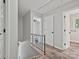 Upstairs hallway features modern railing, grey walls, and white doors leading to bedrooms at 2544 Cedarwild Rd, Charlotte, NC 28212