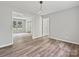 Open-concept living area with modern lighting, gray walls, updated floors, and easy access to other rooms at 2544 Cedarwild Rd, Charlotte, NC 28212