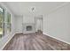 Clean and bright living room featuring hardwood floors, a modern fireplace, and a large window for natural light at 2544 Cedarwild Rd, Charlotte, NC 28212