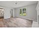 Light-filled living room with hardwood floors, fireplace, large window, and an open view to the bathroom at 2544 Cedarwild Rd, Charlotte, NC 28212