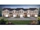 Row of new townhomes showing the exterior facade, well maintained lawns and individual garages at 2927 Penninger Cir, Charlotte, NC 28262