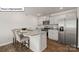 Compact kitchen with granite countertops, stainless steel appliances, and seating for two at the island at 2939 Penninger Cir, Charlotte, NC 28262