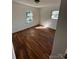 Bedroom showcasing hardwood floors, two windows inviting natural light, and freshly painted white walls at 3048 Marigold Ln, Gastonia, NC 28052
