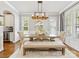 Elegant dining room with wainscoting, large windows, and a rustic chandelier above a farmhouse table at 3101 Auburn Ave, Charlotte, NC 28209