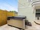 Backyard with hot tub and stone patio beneath string lights and natural light at 3101 Auburn Ave, Charlotte, NC 28209