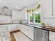 Modern kitchen featuring stainless steel appliances, sleek white cabinetry, and a black granite countertop at 3101 Auburn Ave, Charlotte, NC 28209