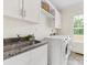 Clean laundry room with granite countertops, stainless steel sink, and a modern washer and dryer at 3101 Auburn Ave, Charlotte, NC 28209