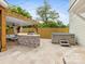 Outdoor kitchen with built-in grill, cabinetry, hot tub, and seating area at 3101 Auburn Ave, Charlotte, NC 28209