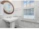 Well-lit powder room featuring a unique round mirror and board and batten wall paneling at 376 Sensibility Cir # 8, Fort Mill, SC 29708