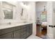 Modern bathroom with dual sinks, gray cabinets, white countertops, and a view into the Primary bedroom at 376 Sensibility Cir # 8, Fort Mill, SC 29708
