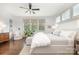 Bright bedroom featuring a ceiling fan, hardwood floors, many windows, and a white chair at 376 Sensibility Cir # 8, Fort Mill, SC 29708