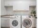 Clean laundry room featuring modern washer and dryer units, a sink, and white cabinets at 376 Sensibility Cir # 8, Fort Mill, SC 29708