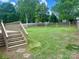 Backyard featuring a large grassy area, wooden deck with stairs, and a wooden fence at 3776 Kennedy Rd, Gastonia, NC 28056