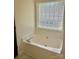 Bathroom featuring tub, privacy window, and marble floors at 3776 Kennedy Rd, Gastonia, NC 28056