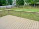 A look at a wooden deck with railings, overlooking a large backyard with a wooden fence at 3776 Kennedy Rd, Gastonia, NC 28056