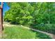 Fenced backyard features green grass, lush trees and landscaping, and an additional patio area at 397 Fischer Rd, Fort Mill, SC 29715