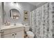 This bathroom features a stylish floral shower curtain, white cabinets, and a round mirror at 397 Fischer Rd, Fort Mill, SC 29715