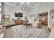 Inviting living room with decoratively paneled walls, a vintage chandelier, and an open staircase at 397 Fischer Rd, Fort Mill, SC 29715