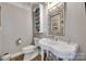 Charming powder room featuring classic fixtures, a decorative mirror, and a whimsical display cabinet at 397 Fischer Rd, Fort Mill, SC 29715