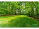 Lush green backyard with mature trees creating a serene setting, ideal for nature lovers and outdoor enjoyment at 4033 Weddington Manor Ct, Matthews, NC 28104