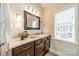 This bathroom features a brown vanity with a marble countertop and a framed mirror above at 4033 Weddington Manor Ct, Matthews, NC 28104