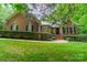 Charming brick home featuring manicured landscaping, a walkway leading to the front door, and complemented by lush greenery at 4033 Weddington Manor Ct, Matthews, NC 28104