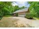 View of the home's brick side exterior with a multi-car garage and well-maintained landscaping for added curb appeal at 4033 Weddington Manor Ct, Matthews, NC 28104