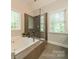 This main bathroom features a soaking tub, a glass enclosed shower, and a large window at 4033 Weddington Manor Ct, Matthews, NC 28104