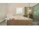This main bathroom features a soaking tub with a glass block window and a separate glass enclosed shower at 4033 Weddington Manor Ct, Matthews, NC 28104