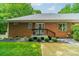 Back of brick home with a cozy porch, wooden steps, and landscaping, blending comfort and natural beauty at 4033 Weddington Manor Ct, Matthews, NC 28104