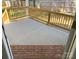 Enclosed back porch with concrete flooring, brick base and wood railing at 4049 Fincher Rd # 3, Matthews, NC 28104