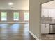 Spacious living room featuring hardwood floors, three large windows, and a view into the modern kitchen at 4049 Fincher Rd # 3, Matthews, NC 28104