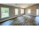 Bright living room featuring hardwood floors, neutral walls, a modern chandelier, and ample natural light at 4049 Fincher Rd # 3, Matthews, NC 28104