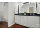 Bathroom featuring dual sinks with black granite countertops and white cabinetry at 4132 Kenton Glenn Nw Ct, Concord, NC 28027