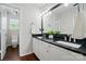 Bathroom features dual sinks with black granite countertops, stylish lighting, and white cabinetry at 4132 Kenton Glenn Nw Ct, Concord, NC 28027