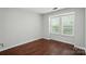 This is a bright bedroom with hardwood floors and natural light streaming through the window at 4132 Kenton Glenn Nw Ct, Concord, NC 28027