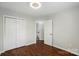 Bright bedroom featuring hardwood floors, closet, neutral paint, and ensuite bathroom access at 4132 Kenton Glenn Nw Ct, Concord, NC 28027