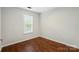 This is a bright bedroom with hardwood floors and natural light streaming through the window at 4132 Kenton Glenn Nw Ct, Concord, NC 28027