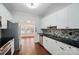 Updated kitchen features white cabinets, stainless steel appliances, mosaic backsplash, and black countertops at 4132 Kenton Glenn Nw Ct, Concord, NC 28027