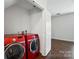 Convenient laundry closet with red front load washer and dryer, located just off the bedroom at 4132 Kenton Glenn Nw Ct, Concord, NC 28027