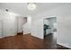 Open living room featuring hardwood floors, staircase, and entrance to the kitchen with stainless appliances at 4132 Kenton Glenn Nw Ct, Concord, NC 28027