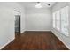 Well-lit living room boasts hardwood floors, neutral walls, and view to kitchen with stainless steel refrigerator at 4132 Kenton Glenn Nw Ct, Concord, NC 28027
