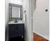 Stylish powder room features a decorative mirror, black vanity with marble countertop at 4132 Kenton Glenn Nw Ct, Concord, NC 28027