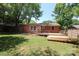 Exterior view of brick home with backyard decks, manicured lawn and mature trees at 4361 Applegate Rd, Charlotte, NC 28209
