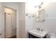 Tiled bathroom showcases a black vanity with sink, mirrored medicine cabinet, and decorative lighting at 4361 Applegate Rd, Charlotte, NC 28209